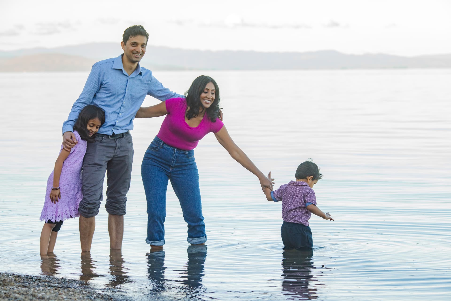 Geetha steadying her young son at the water's edge